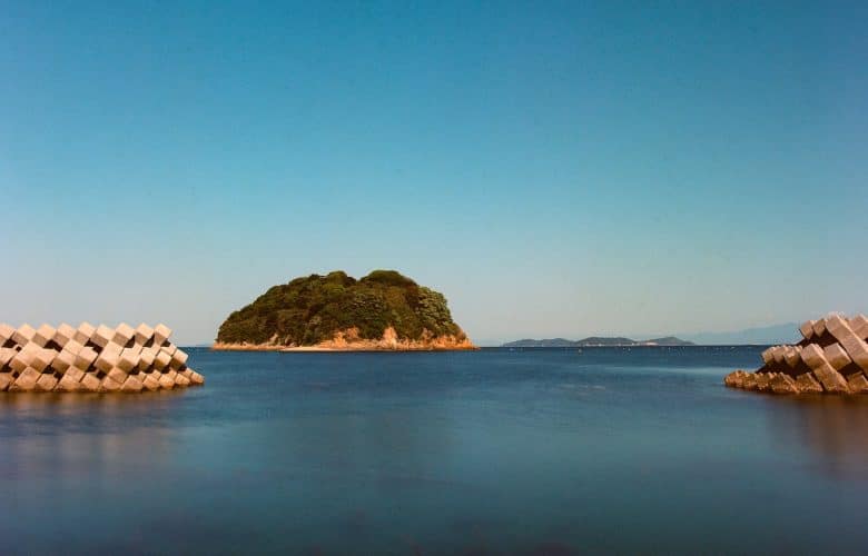 brown rock formation on body of water during daytime