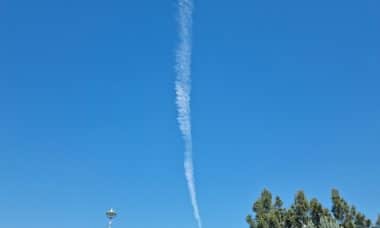 an airplane is flying in the blue sky