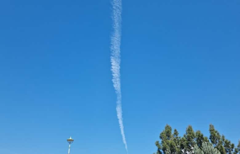 an airplane is flying in the blue sky